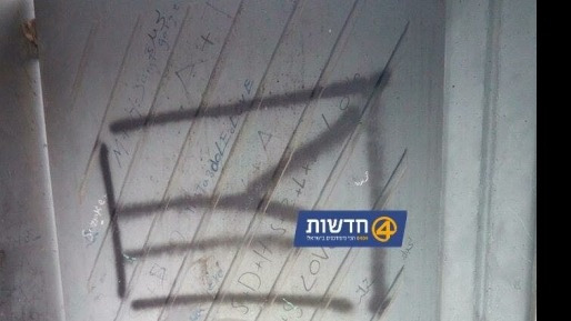 فلسطينيون يرسمون علم فلسطين على جدار مستوطنة