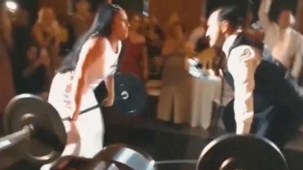 بالفيديو.. عروس تتحدى زوجها برفع الأثقال خلال حفل الزفاف