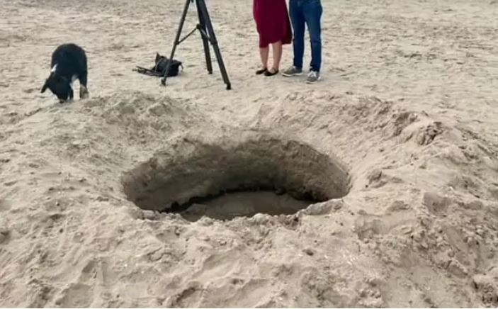 فيديو: فضائيون أم نيزك.. حفرة كبيرة على الشاطئ تثير الجدل!